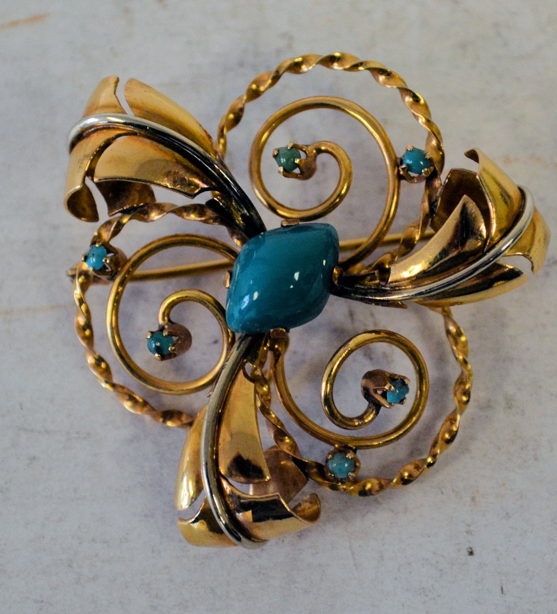 A 15ct Pierced Scalloped Shape Brooch having leaf motifs inset with turquoise 11.8gms gross