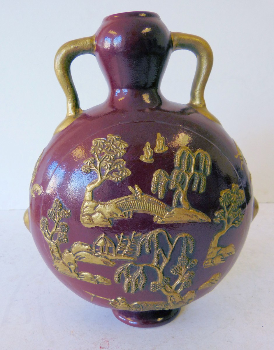 An Oriental 2 Handled Flask on red and gilt ground having raised fish, landscape and floral