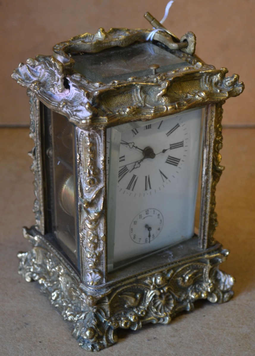 A Reproduction Repeat Striking Carriage Clock, having all over raised floral, leaf an scroll