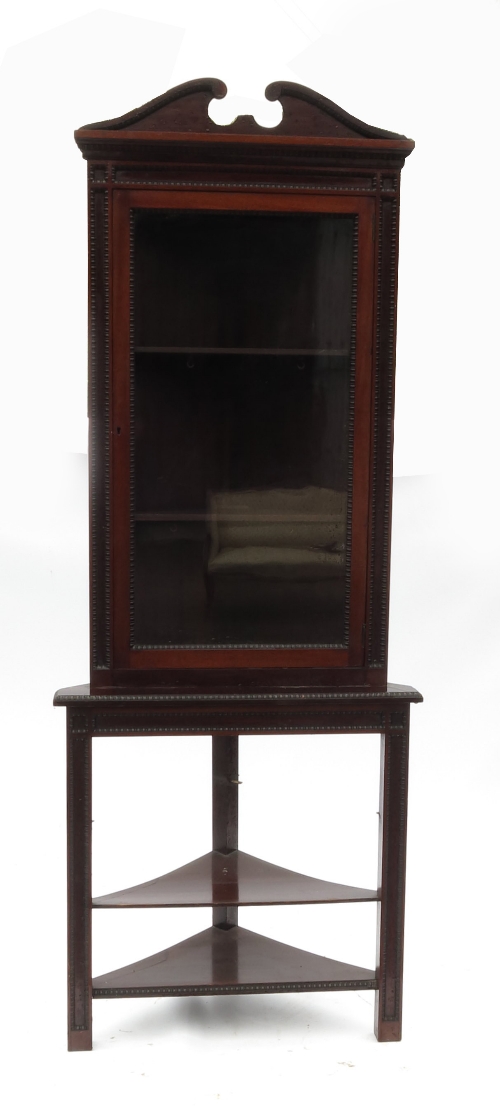 An Edwardian mahogany glazed bookcase, raised on a freestanding base, with glazed door opening to