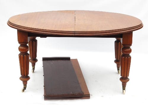 A 19th century mahogany extending dining table, with D-shaped ends raised on four heavily reeded