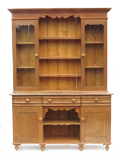 A Victorian oak kitchen dresser, with rack over, and glazed side cabinets flanking open shelves,