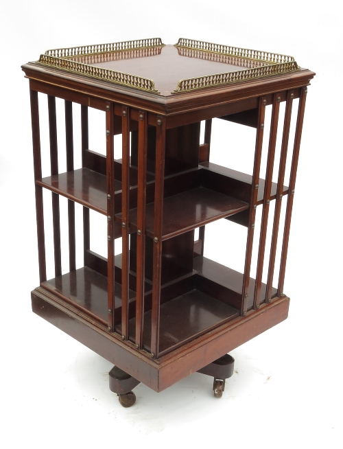 An Edwardian mahogany two tier revolving bookcase, having gilded balustrade gallery over, width