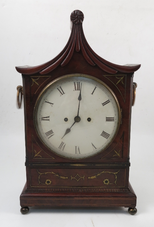 A Regency mahogany cased mantel clock, with white enamel dial and Roman numerals, the brass back