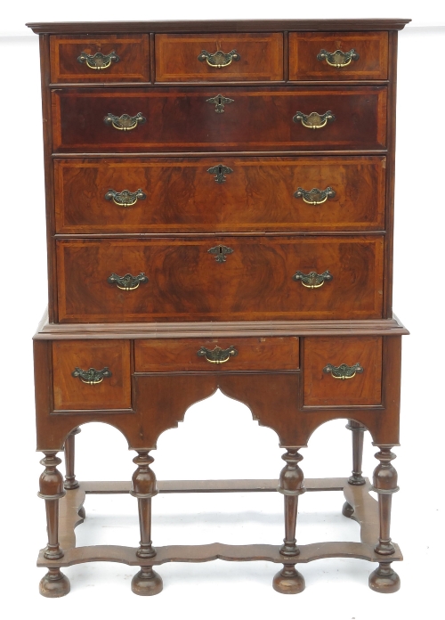 A walnut chest on stand, the upper section fitted three short drawers over three long drawers,