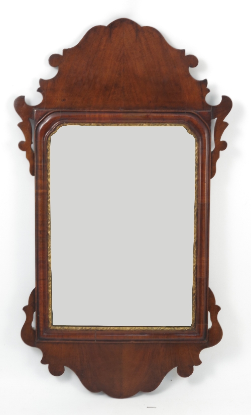 A Georgian design mahogany fret cut mirror, with shaped pediment and apron, having a gilt slip,