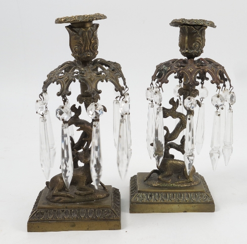 A pair of 19th century brass lustre candlesticks, formed as a recumbent deer at the base of a