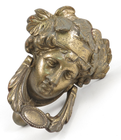 A gilt metal door knocker, decorated in the classical style with a mask and swags, height 7ins