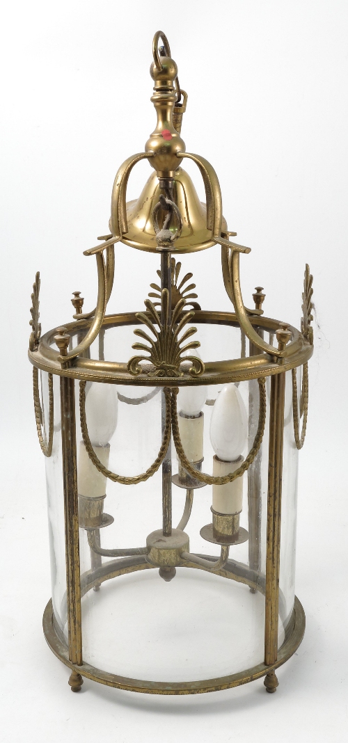 A brass and glass cylindrical light fitting, decorated with gilt swags and anthemion motifs, with