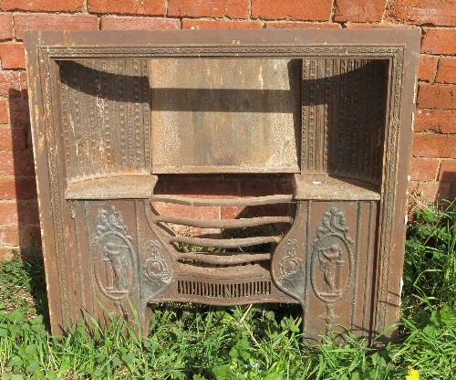 An Edwardian iron fireplace, with central breaks flanked by moulded panels within a square frame,