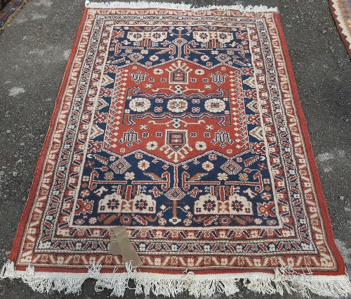 An Eastern rug, with blue and orange field decorated with a repeating design, 4ft1 x 5ft9