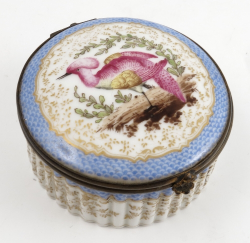 A 19th century continental porcelain covered circular box, the cover decorated with a fabulous