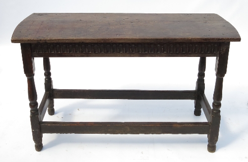 An Antique oak centre table, with carved frieze, raised on turned legs united by stretchers, width