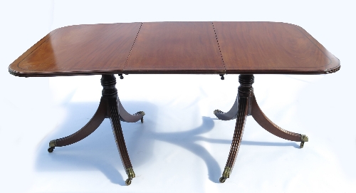 A 19th century Regency design mahogany twin pillared dining table, with ebonised line inlay,