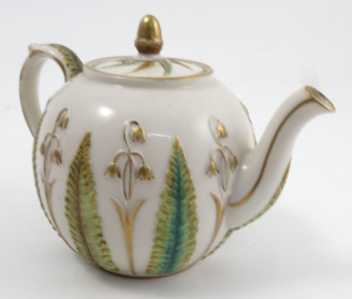 A Victorian porcelain tea pot, the white ground embossed with coloured ferns and harebells, with