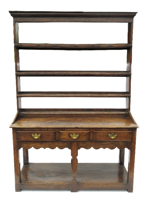 An oak pot board dresser, with three shelf Delft rack over three drawers to the base, with pot board