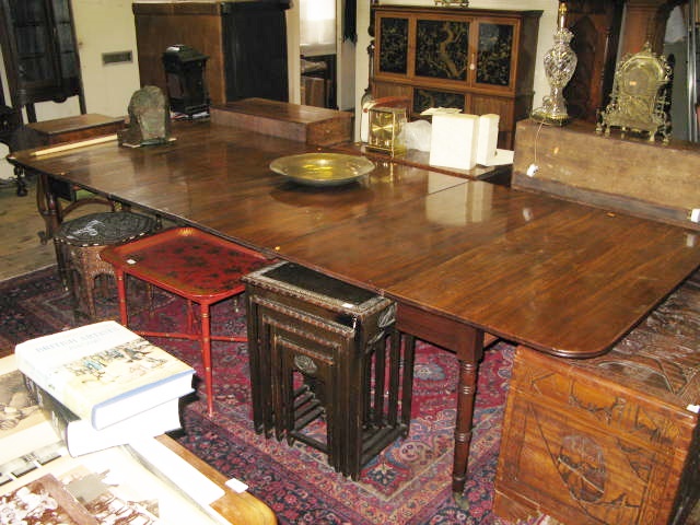 A Georgian Mahogany Concertina Action Extending Dining Table, the two ends with folding laps and