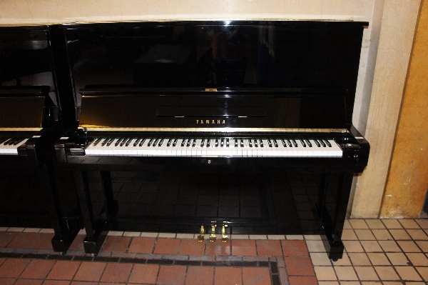 Yamaha 
A Model U3C upright piano in a bright ebonised case.