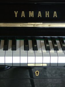 Yamaha 
A Model U1H upright piano in a bright ebonised case.