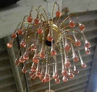 A chandelier with hanging pink crystal glass droplets