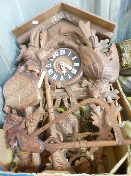 A late 20th century Black Forest carved cuckoo clock decorated with applied game, rifles and oak