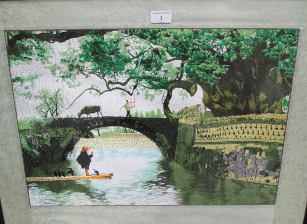 An embroidered Japanese art work of a river and bridge