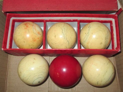 Five early 20th century ivory billiard balls and one other