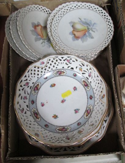 A box of hand-painted and transfer printed pierced porcelain plates decorated with floral sprays and