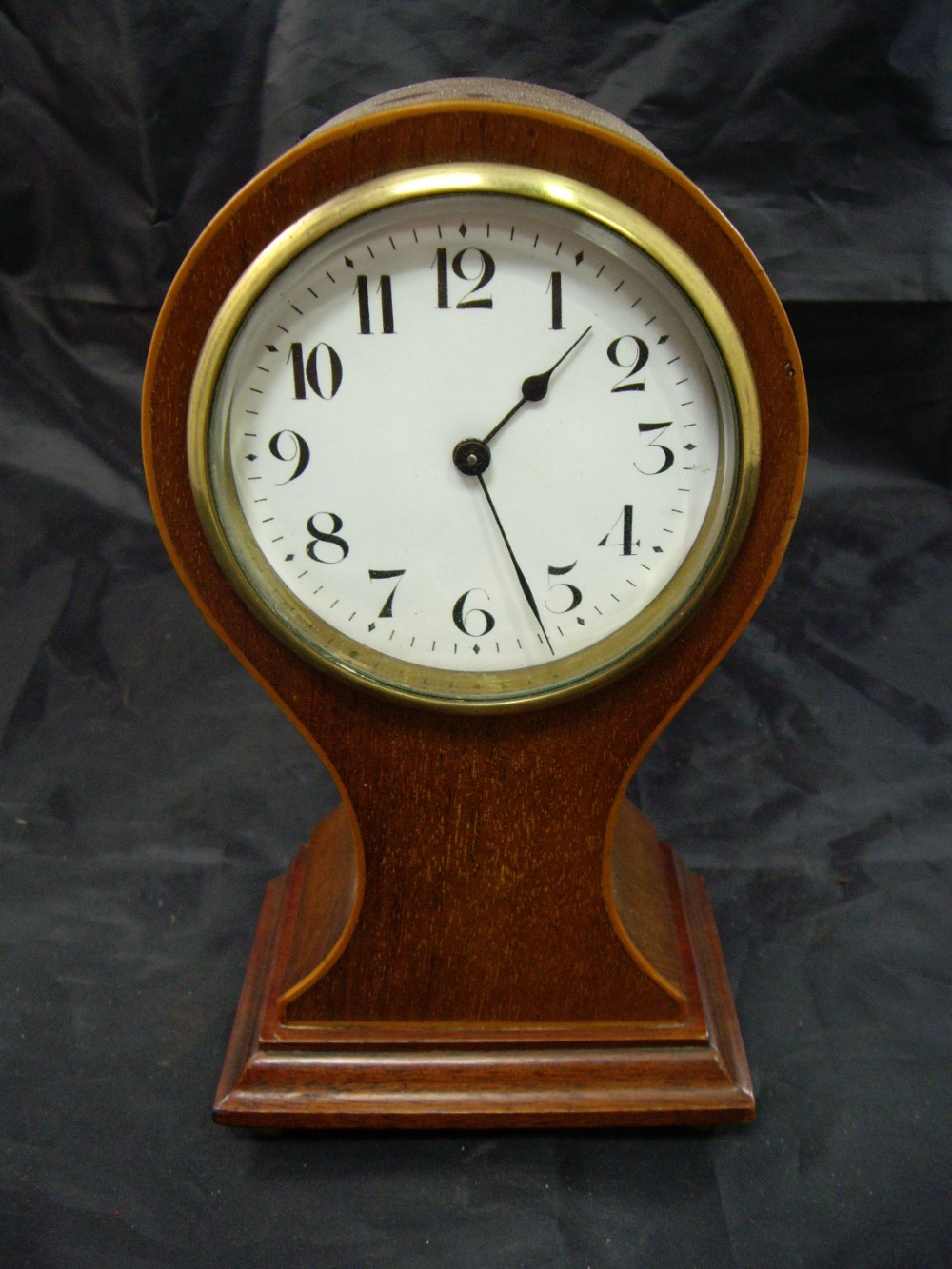 An Edwardian line inlaid walnut balloon clock with enamel dial and Arabic numerals, the brass