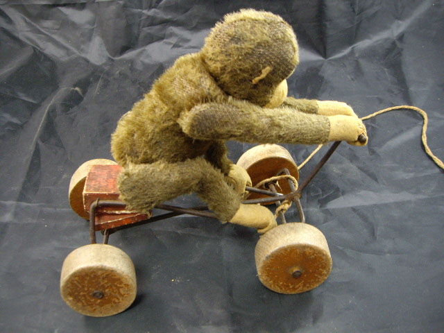 An early 20th century Steiff-style mohair monkey with glass eyes, felt face, hands and feet,