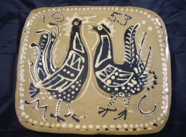 A mid-20th century studio pottery slipware platter in the style of Michael Cardew, decorated with