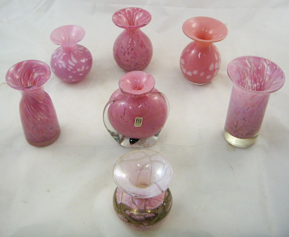 Seven small Mdina glass vases, all with pink mottled ground and flared rims, each engraved with