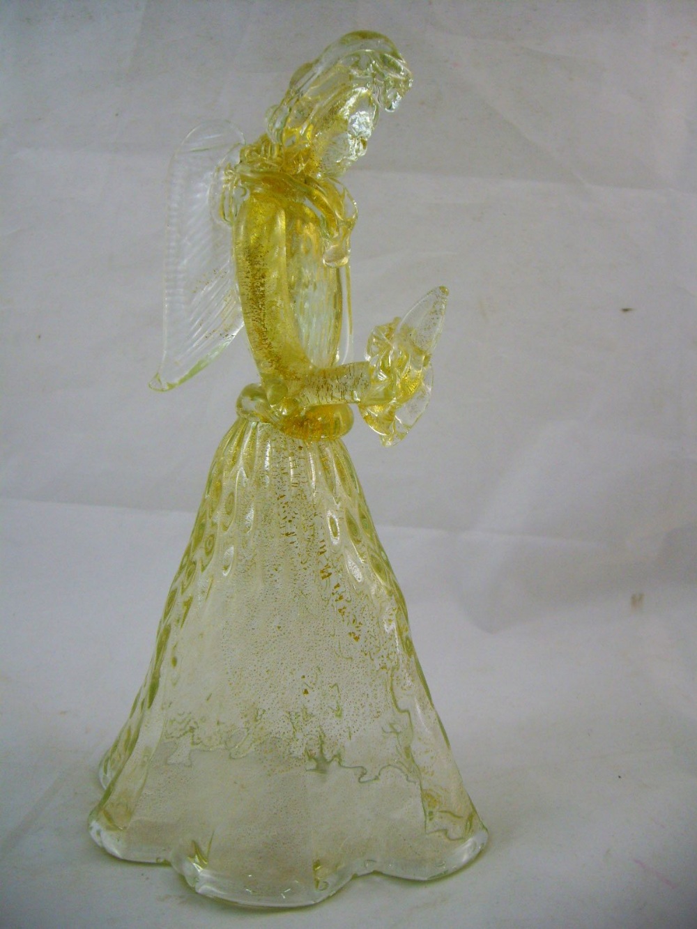 A Murano Seguso glass standing angel with raised palms and gilt inclusions, 26cm high