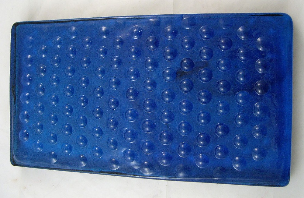 A 20th century studio art glass slab of rectangular form with moulded nail head decoration on a