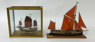 Two small model boats including a sailing barge and a Chinese junk
