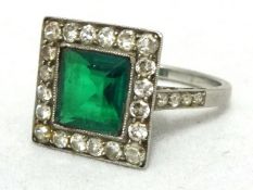 An diamond cluster ring set in platinum with green stone, size L