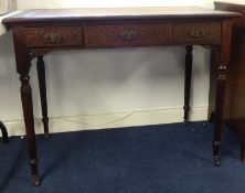 Mahogany three drawer writing table with fluted legs and blind fretwork carving, 96cm wide