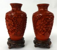 A pair of Chinese red cinnabar lacquered vases with hardwood stands, 16cm