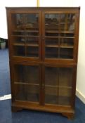 An oak two section glazed book case on stand