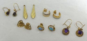 A collection of various pairs of earrings including gold