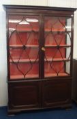 Mahogany half glazed display cabinet in two sections, 130cm wide