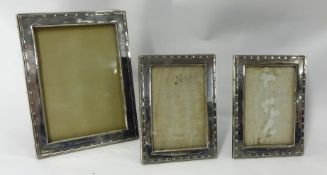 Three matching silver photo frames, largest 23cm x 18cm