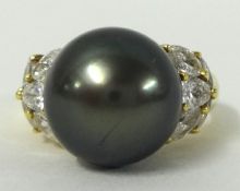 A black pearl and diamond set ring, size Q, stamped 750