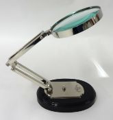 An angle poise magnifying glass on stand