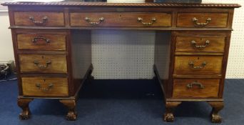 A mahogany pedestal desk fitted with nine drawers on ball feet, 136cm x 74cm
