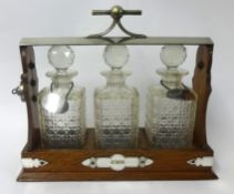 Three bottle and silver plated Tantalus inscribed F.M.W.,1903 `From The Tramp`