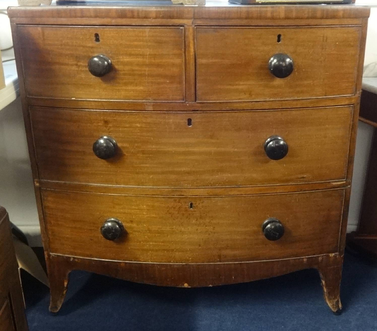 Early 19th century small mahogany bow fronted chest fitted with four drawers on splayed feet