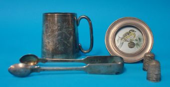Silver and engraved christening mug, silver tongs and small circular photo frame and two thimbles (