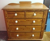 A pitch pine chest of drawers with two short and three long drawers, with white china knob handles