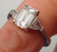 A fine diamond ring set with emerald cut diamond approximately 1.00 ct with further diamonds to the